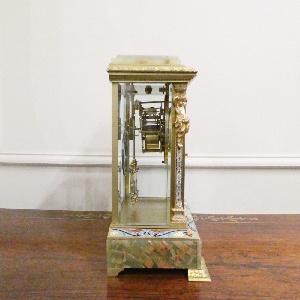 A late nineteenth-century French four-glass mantel clock featuring a green onyx base and top, champleve enamel borders, and a visible mercury pendulum. View XIII