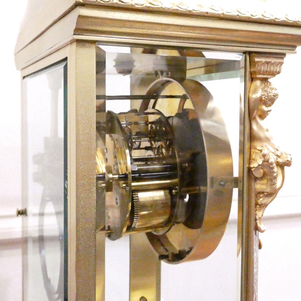A late nineteenth-century French four-glass mantel clock featuring a green onyx base and top, champleve enamel borders, and a visible mercury pendulum. View XIV