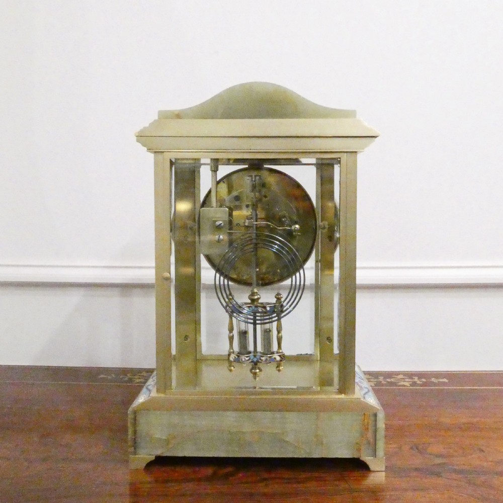 A late nineteenth-century French four-glass mantel clock featuring a green onyx base and top, champleve enamel borders, and a visible mercury pendulum. View XV