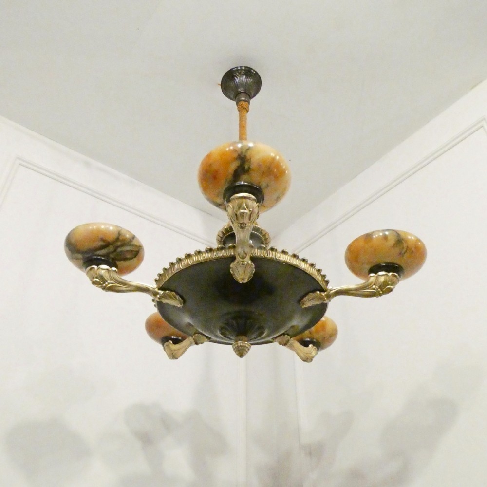 An Art Deco bronze chandelier featuring carved alabaster shade cups suspended from a corded stem with decorative tassel detail. View II