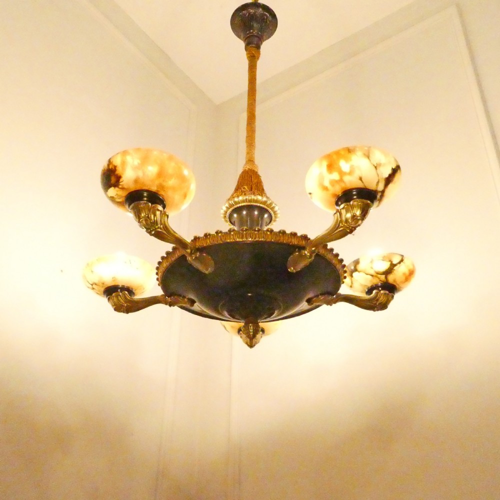 An Art Deco bronze chandelier featuring carved alabaster shade cups suspended from a corded stem with decorative tassel detail. View III