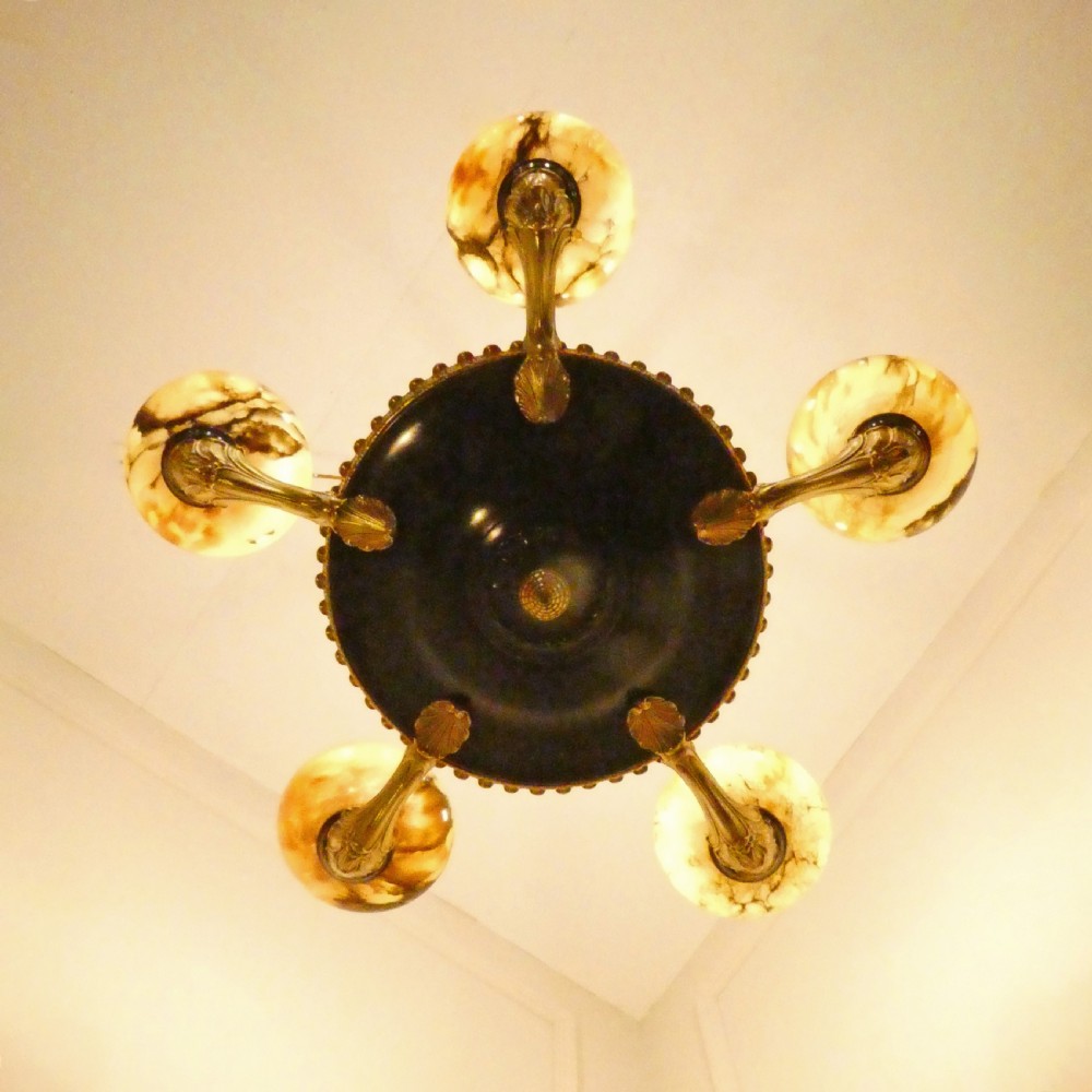 An Art Deco bronze chandelier featuring carved alabaster shade cups suspended from a corded stem with decorative tassel detail. View XVI