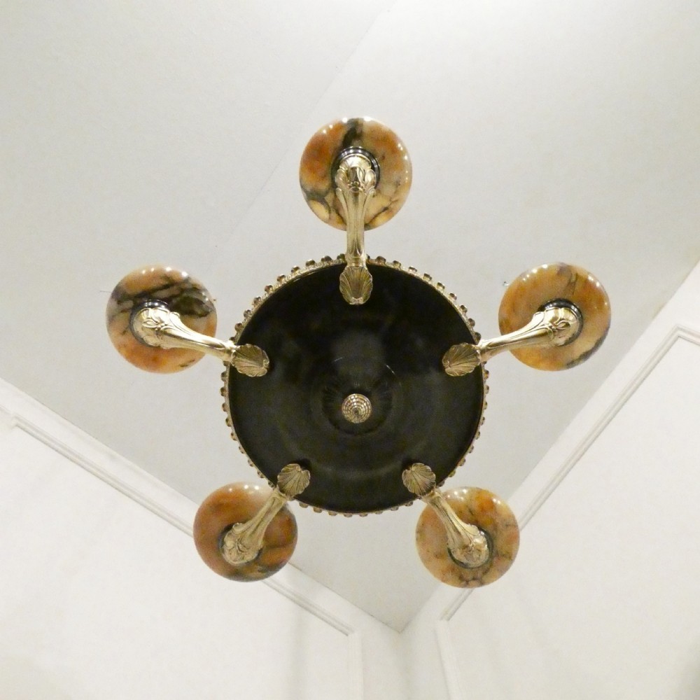 An Art Deco bronze chandelier featuring carved alabaster shade cups suspended from a corded stem with decorative tassel detail. View XVII