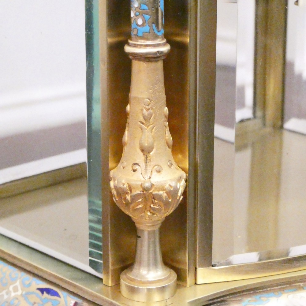 An antique French four-glass mantel clock featuring green onyx bases, champleve enamel columns, and a visible brass movement. View V