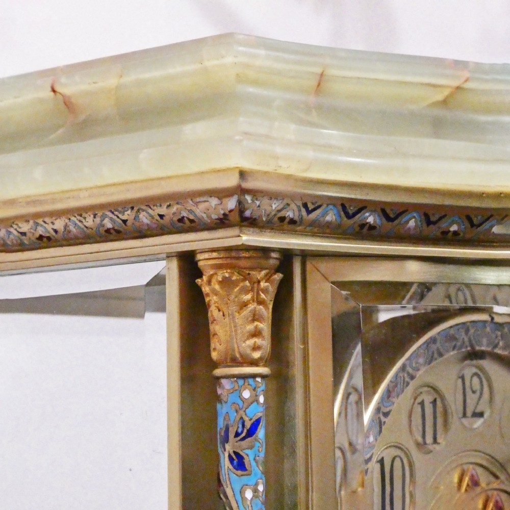 An antique French four-glass mantel clock featuring green onyx bases, champleve enamel columns, and a visible brass movement. View VII