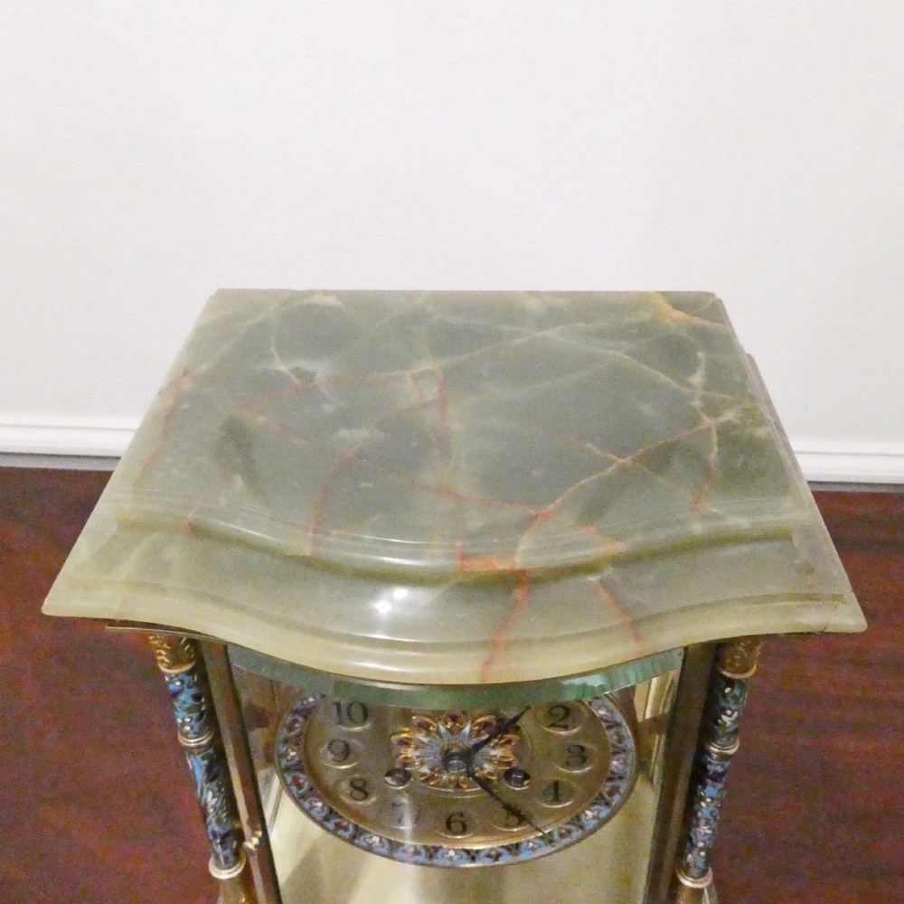 An antique French four-glass mantel clock featuring green onyx bases, champleve enamel columns, and a visible brass movement. View VIII