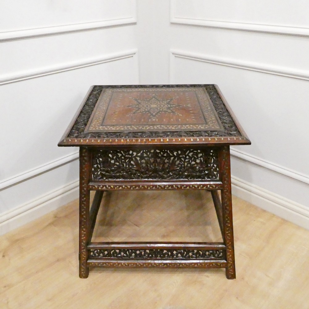 A late 19th-century square Anglo-Indian side table featuring brass inlay with a central star motif and pierced carved wood aprons.