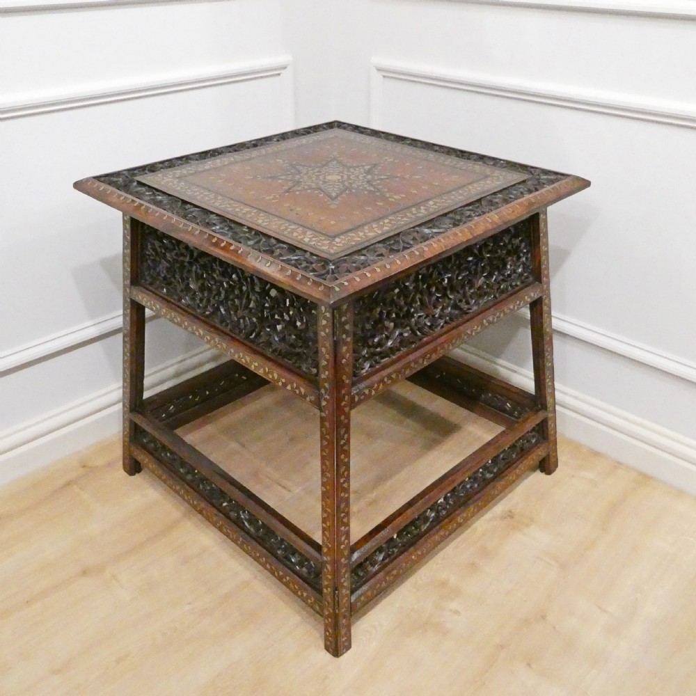 A late 19th-century square Anglo-Indian side table featuring brass inlay with a central star motif and pierced carved wood aprons. View IX