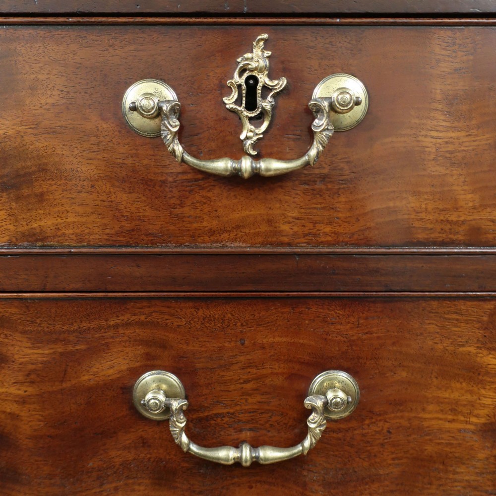 A Georgian Chippendale period mahogany chest on chest featuring two upper short drawers over five long drawers with brass swan-neck handles and carved bracket feet. View II
