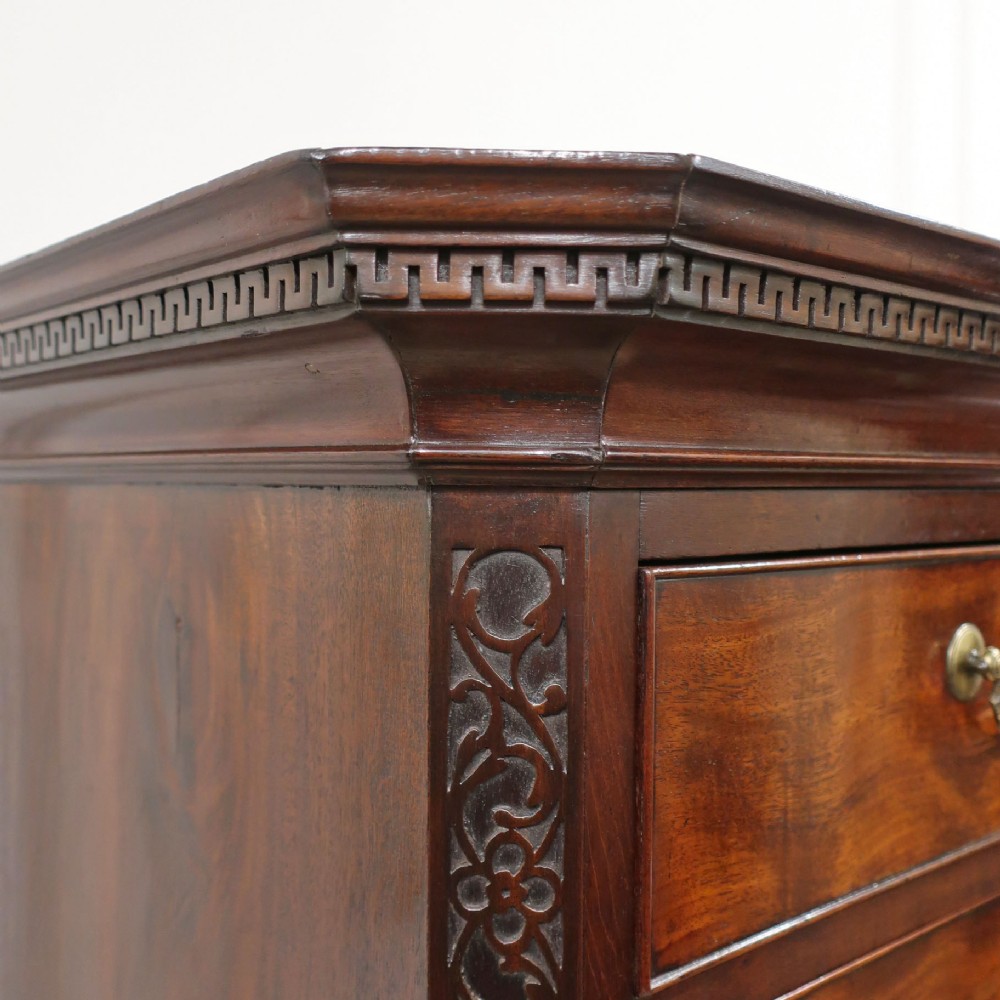 A Georgian Chippendale period mahogany chest on chest featuring two upper short drawers over five long drawers with brass swan-neck handles and carved bracket feet. View V