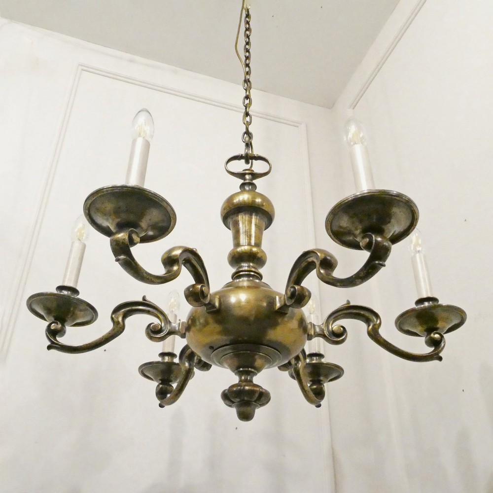 An Edwardian six-light aged brass chandelier featuring a central turned baluster shaft, scrolled arms, and candle sleeves. View XI