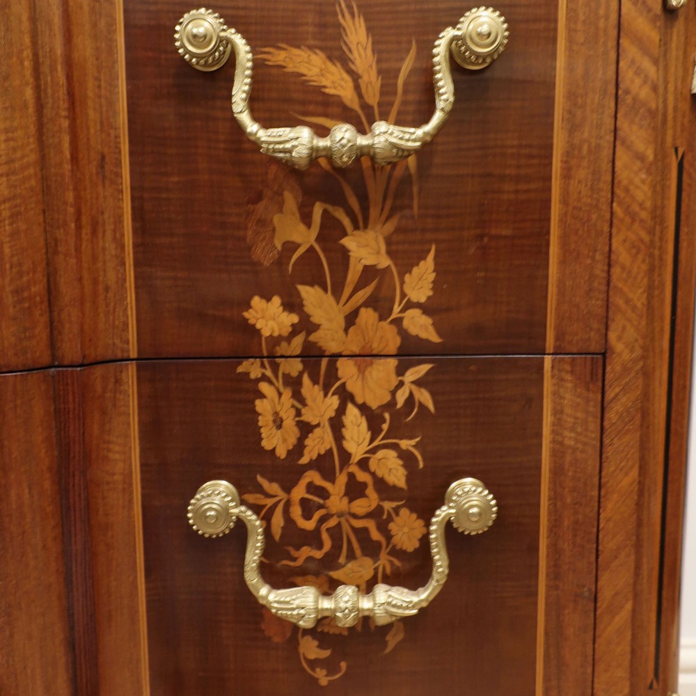 A French Louis XVI style marquetry chest of drawers featuring inlaid central medallion motifs, gilded bronze handles, tapered legs, and a fitted marble top. View VII