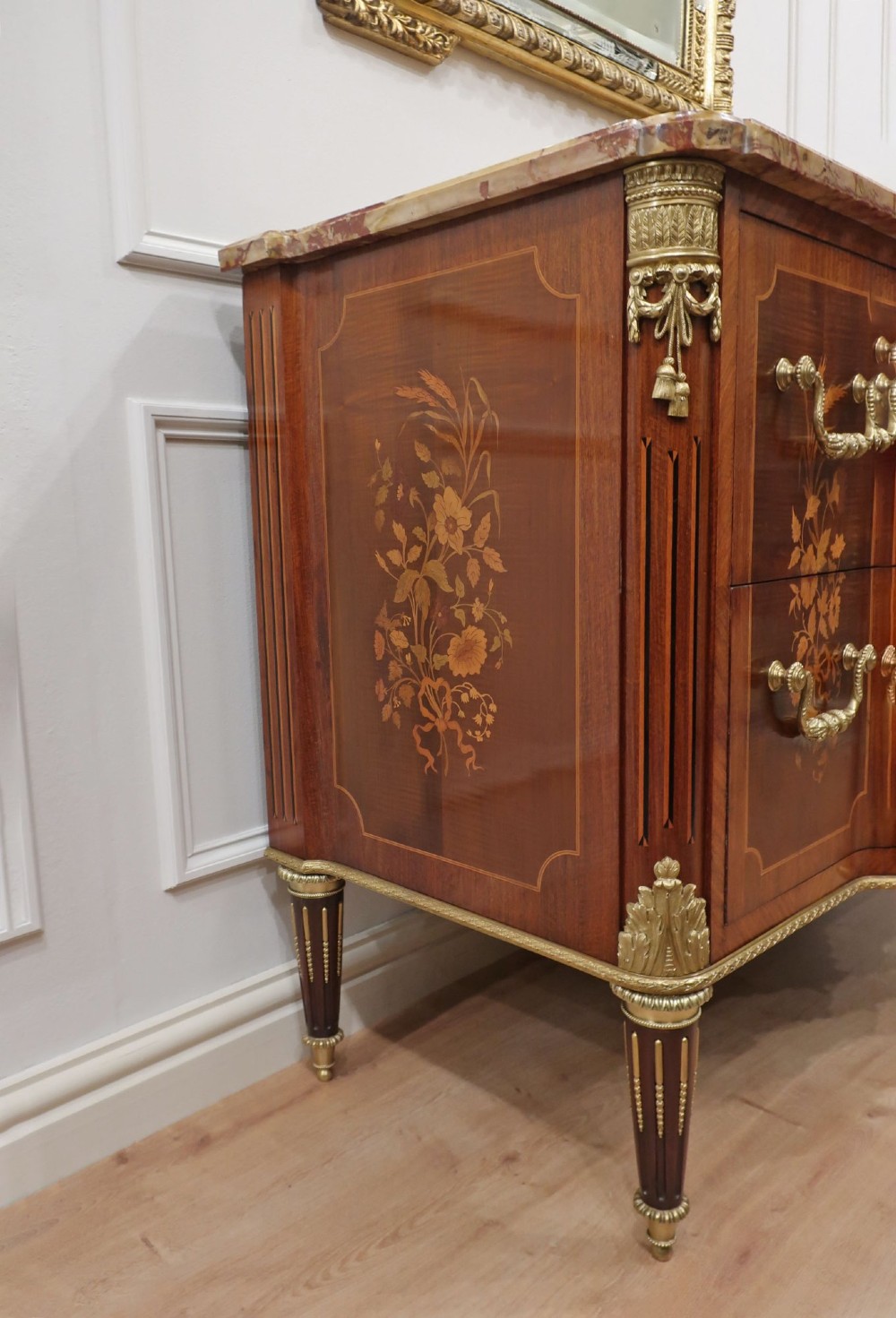 A French Louis XVI style marquetry chest of drawers featuring inlaid central medallion motifs, gilded bronze handles, tapered legs, and a fitted marble top. View XI