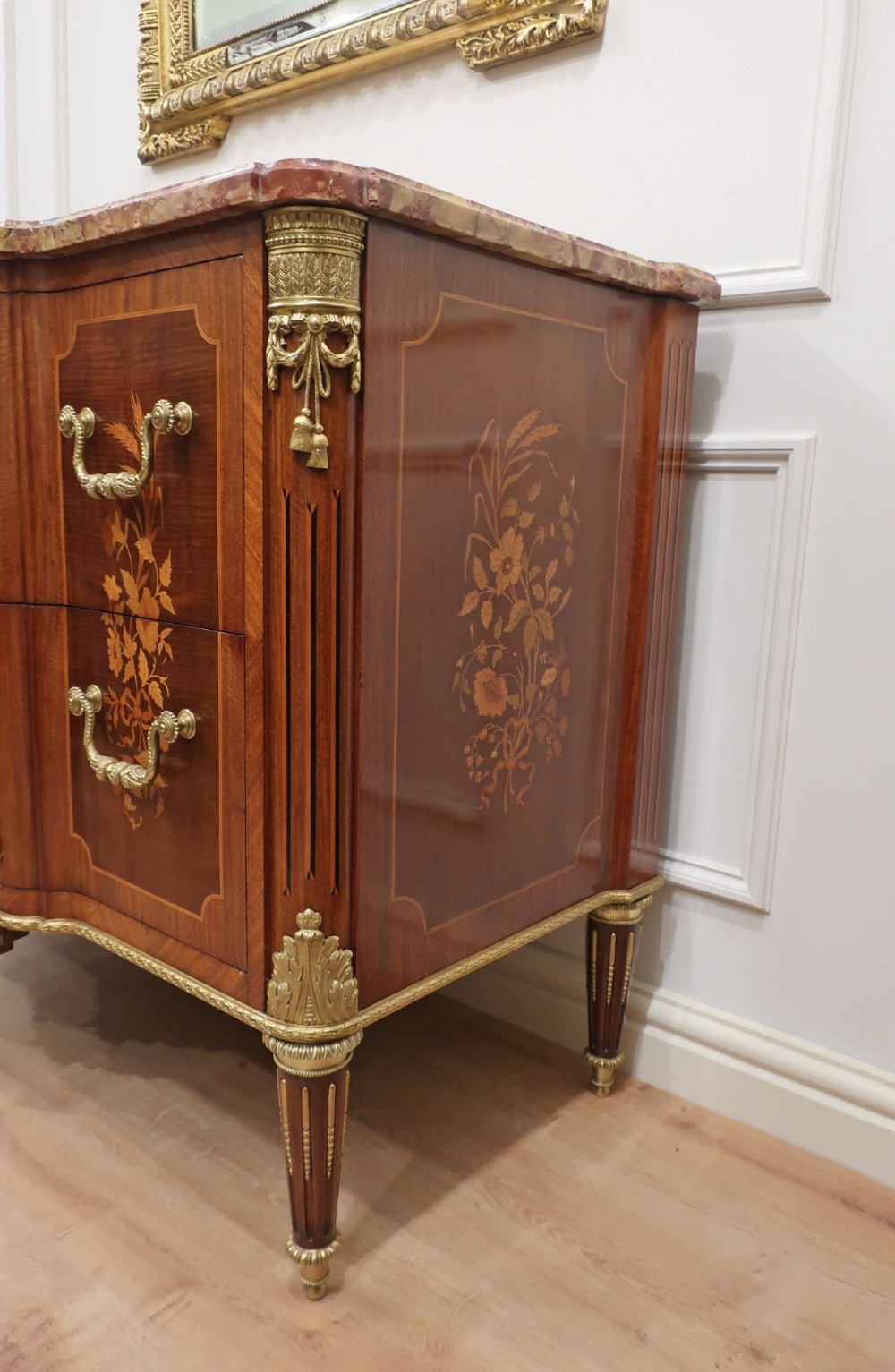 A French Louis XVI style marquetry chest of drawers featuring inlaid central medallion motifs, gilded bronze handles, tapered legs, and a fitted marble top. View XIII