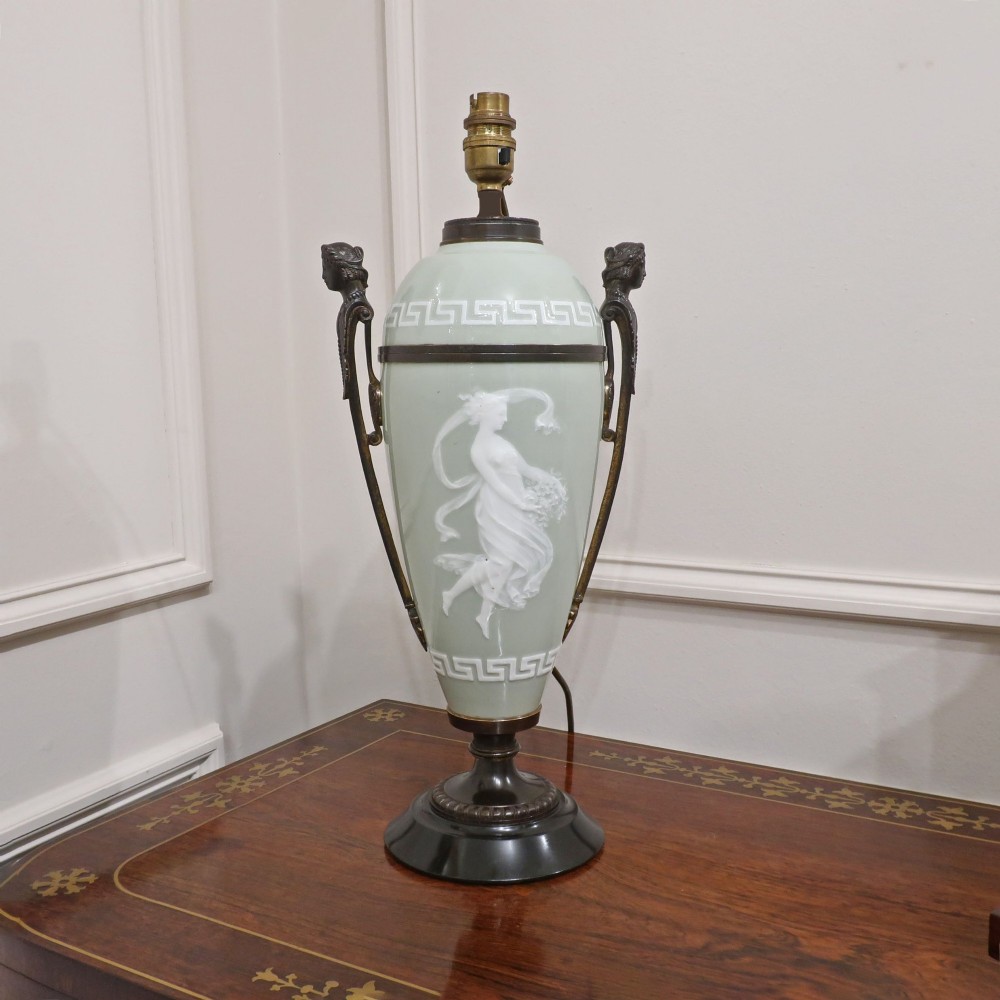 A French Neoclassical style table lamp featuring a pale green pate-sur-pate porcelain urn base, dark bronze side handles, and a pleated cream shade. View II