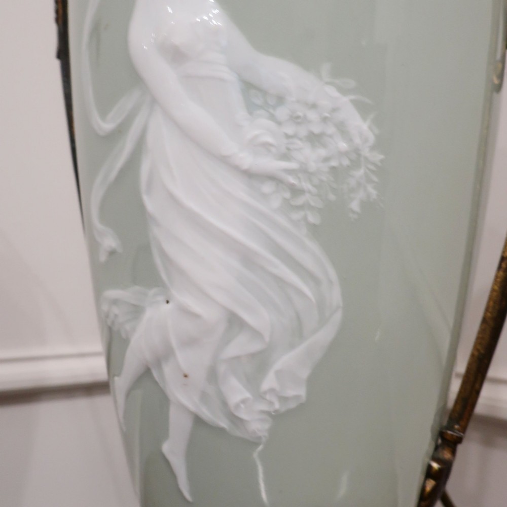 A French Neoclassical style table lamp featuring a pale green pate-sur-pate porcelain urn base, dark bronze side handles, and a pleated cream shade. View IV