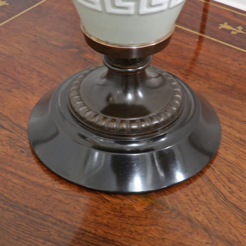A French Neoclassical style table lamp featuring a pale green pate-sur-pate porcelain urn base, dark bronze side handles, and a pleated cream shade. View VI