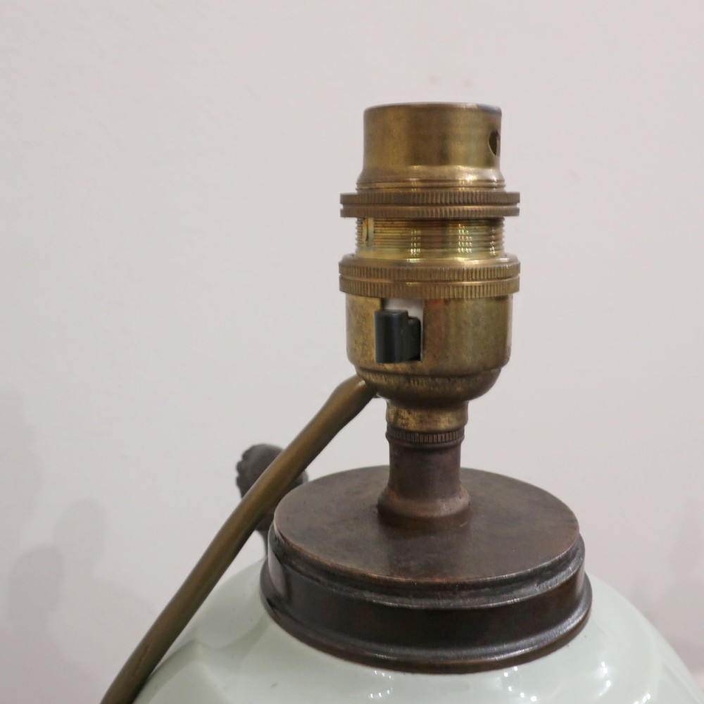 A French Neoclassical style table lamp featuring a pale green pate-sur-pate porcelain urn base, dark bronze side handles, and a pleated cream shade. View XIII