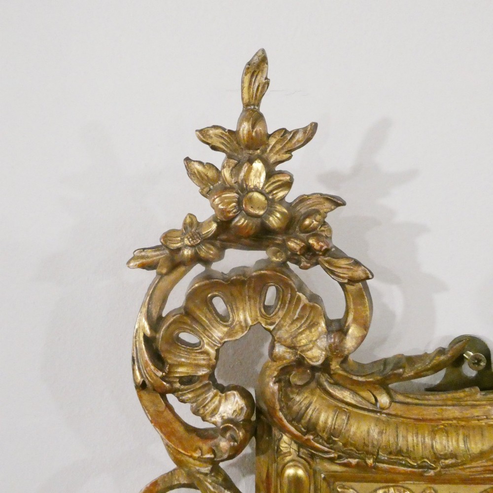 A 19th-century French Louis XVI style gilded wall mirror featuring a carved decorative crest and beaded frame border. View V