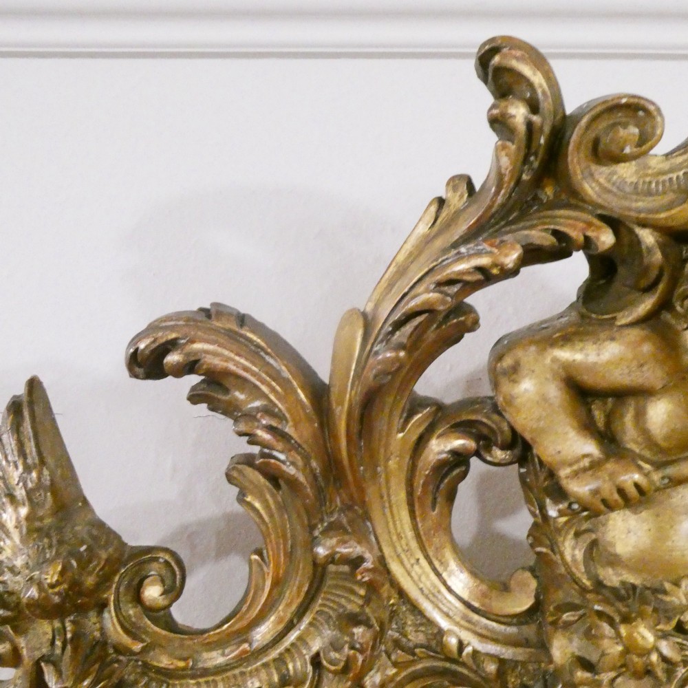 A 19th-century French Louis XVI style gilded wall mirror featuring a carved decorative crest and beaded frame border. View VI