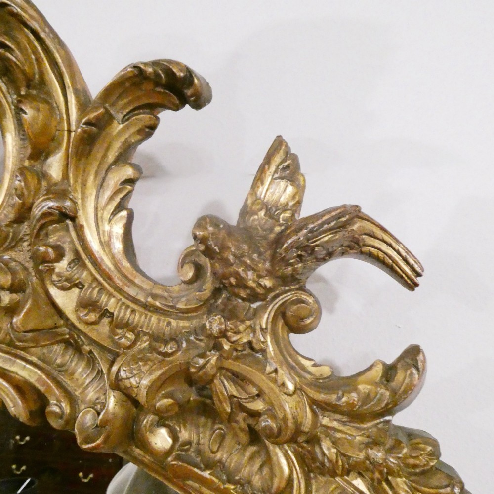 A 19th-century French Louis XVI style gilded wall mirror featuring a carved decorative crest and beaded frame border. View VII
