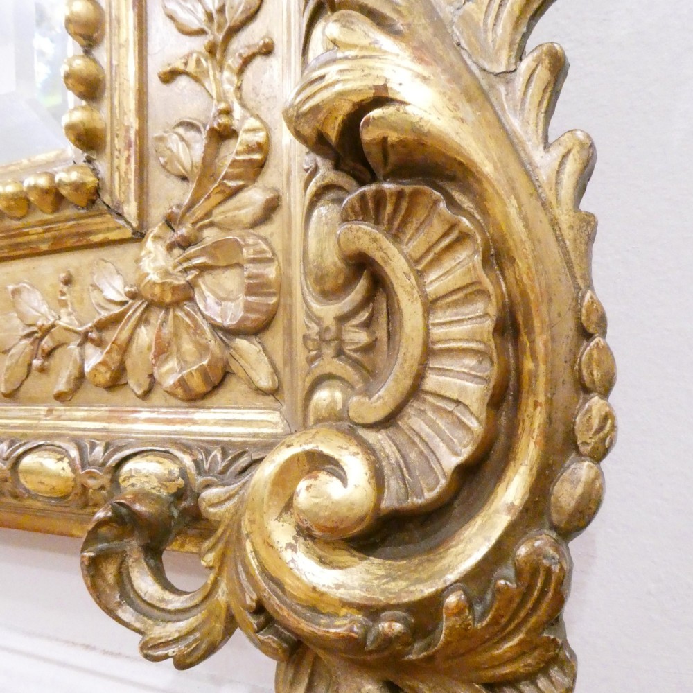 A 19th-century French Louis XVI style gilded wall mirror featuring a carved decorative crest and beaded frame border. View XI