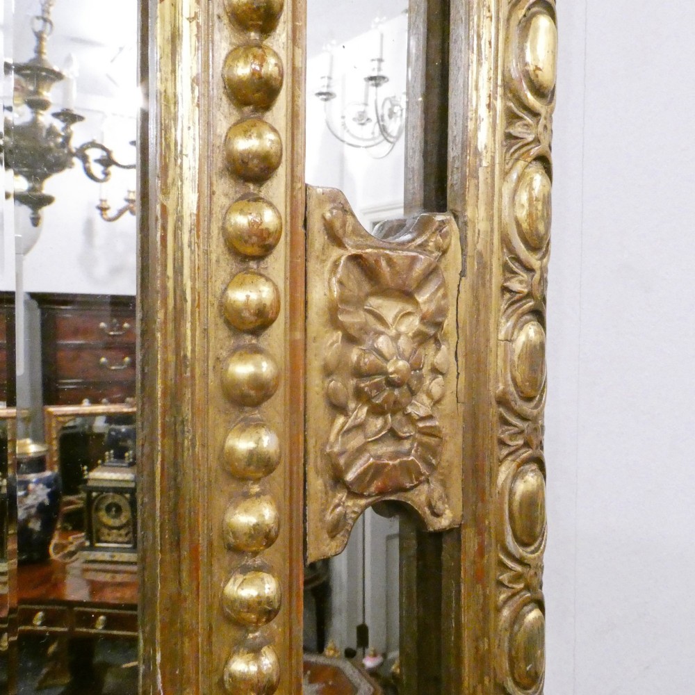A 19th-century French Louis XVI style gilded wall mirror featuring a carved decorative crest and beaded frame border. View XII
