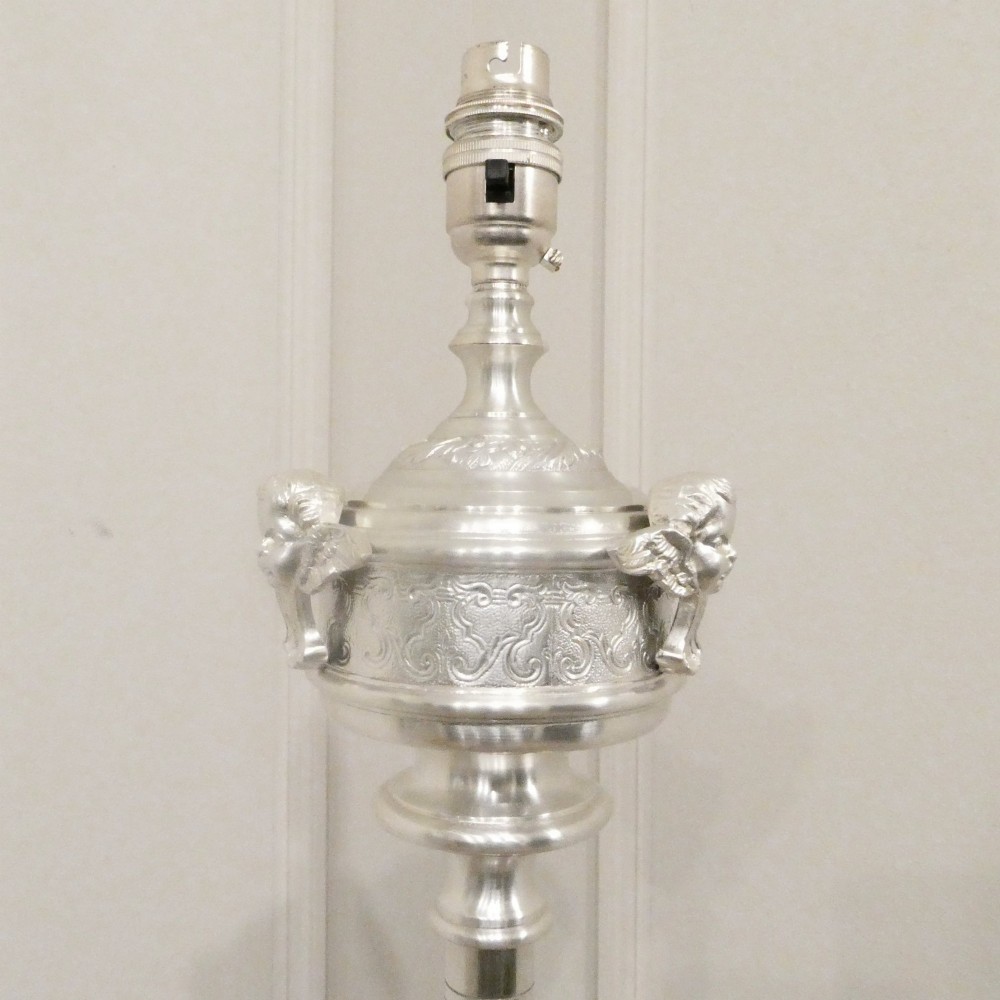An early 20th-century silver-plated standard lamp featuring a turned column, cast base, and a cream scalloped lampshade with fringe detailing. View II