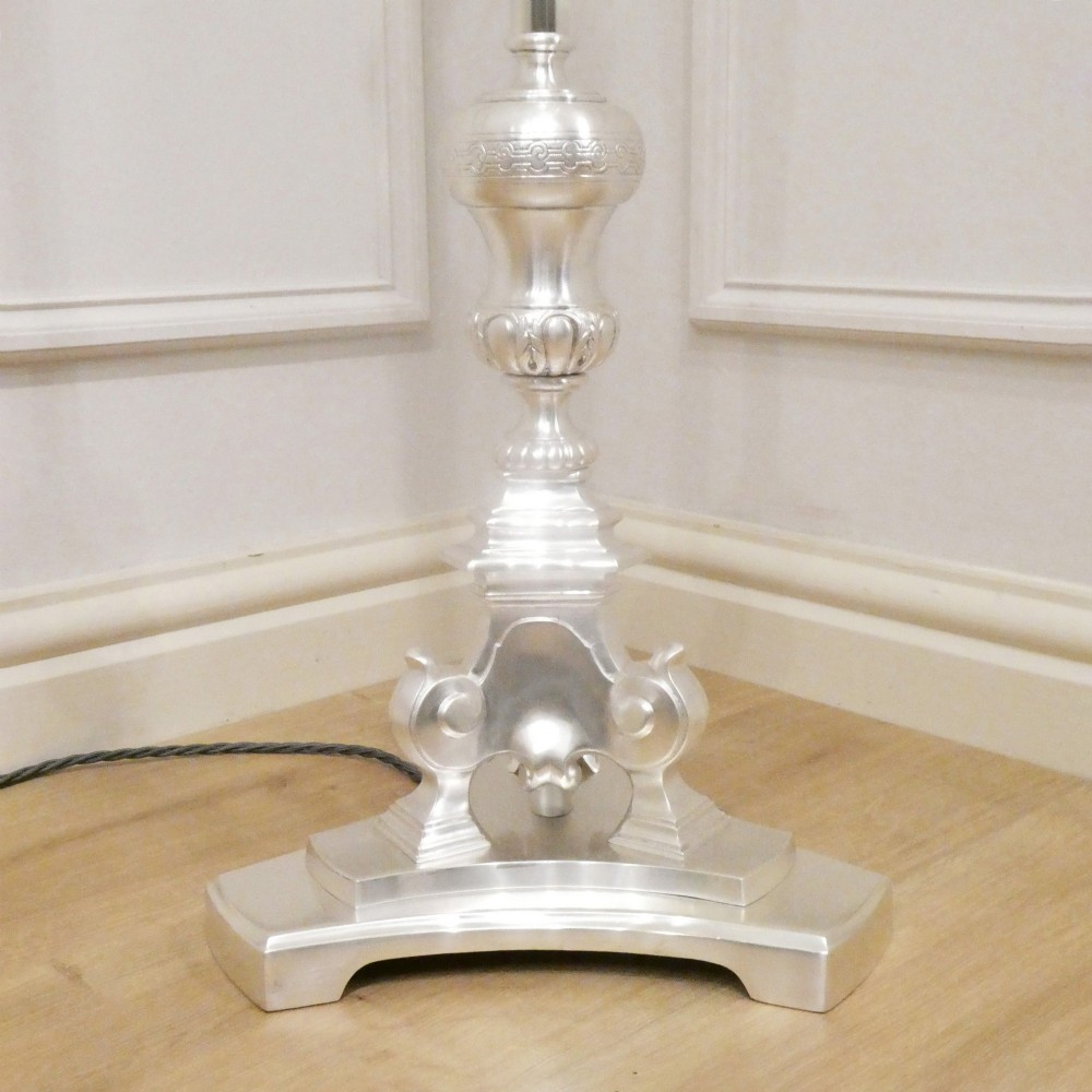 An early 20th-century silver-plated standard lamp featuring a turned column, cast base, and a cream scalloped lampshade with fringe detailing. View VIII