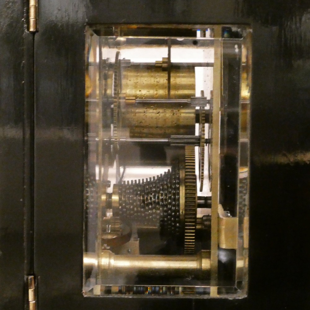 An early Victorian ebonised wooden library clock featuring a square dial with Roman numerals, side viewing apertures, and brass accents. View VIII