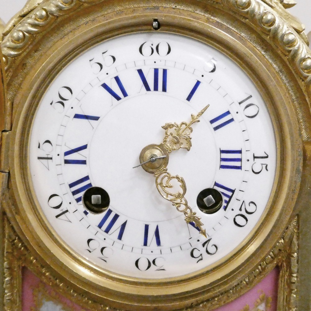 A Louis XVI style gilt bronze mantel clock featuring hand-painted pink porcelain panels and an urn-shaped finial. View II