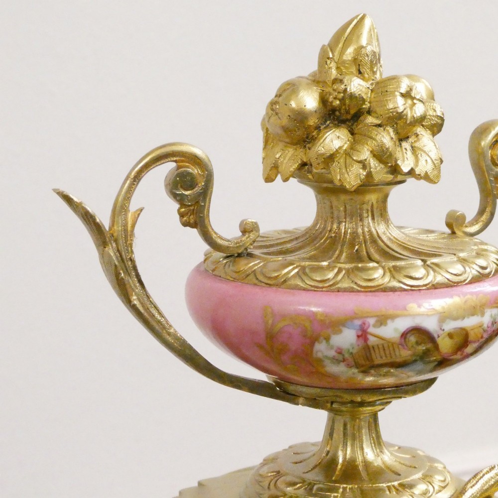 A Louis XVI style gilt bronze mantel clock featuring hand-painted pink porcelain panels and an urn-shaped finial. View VII