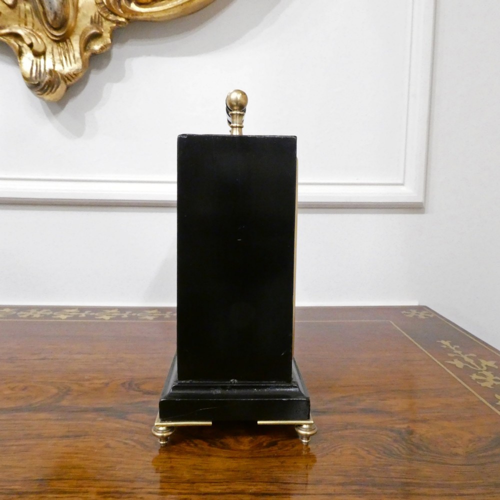 An Edwardian rectangular ebonised wooden mantel clock and barometer unit with twin white circular dials set into a scroll-engraved brass plate. View XI
