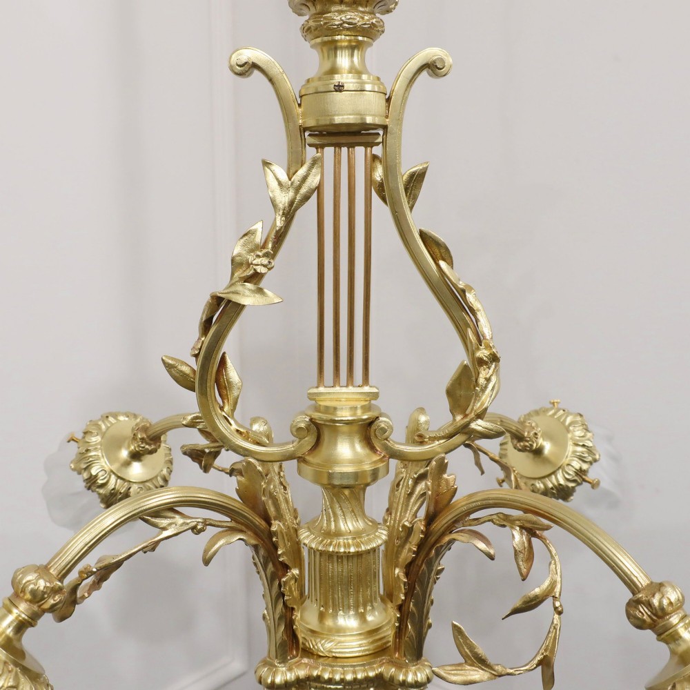 A French Neoclassical style gilt bronze chandelier featuring a central lyre-shaped stem and two outward-curving arms with frosted glass shades. View VI