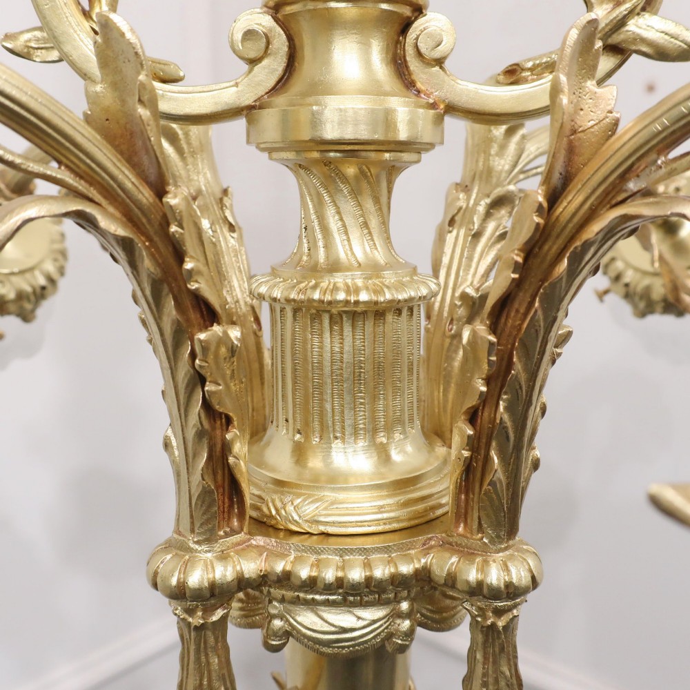 A French Neoclassical style gilt bronze chandelier featuring a central lyre-shaped stem and two outward-curving arms with frosted glass shades. View VIII