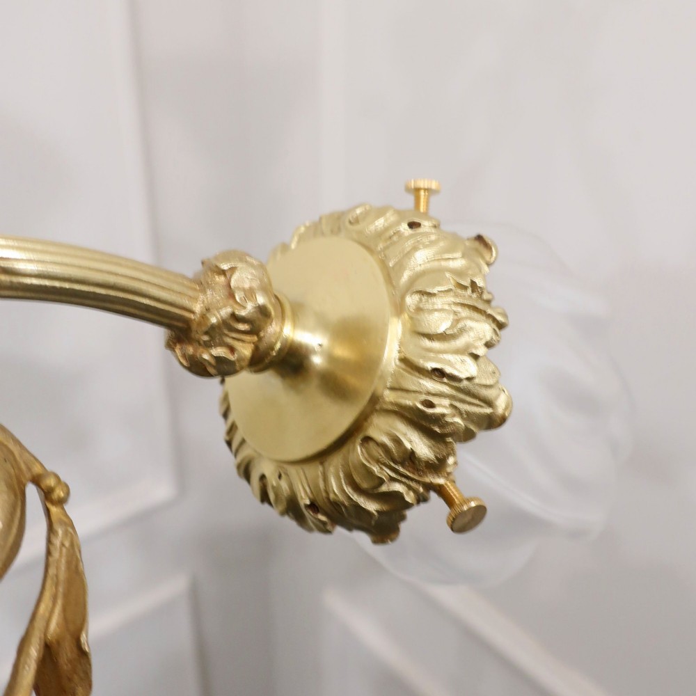 A French Neoclassical style gilt bronze chandelier featuring a central lyre-shaped stem and two outward-curving arms with frosted glass shades. View IX