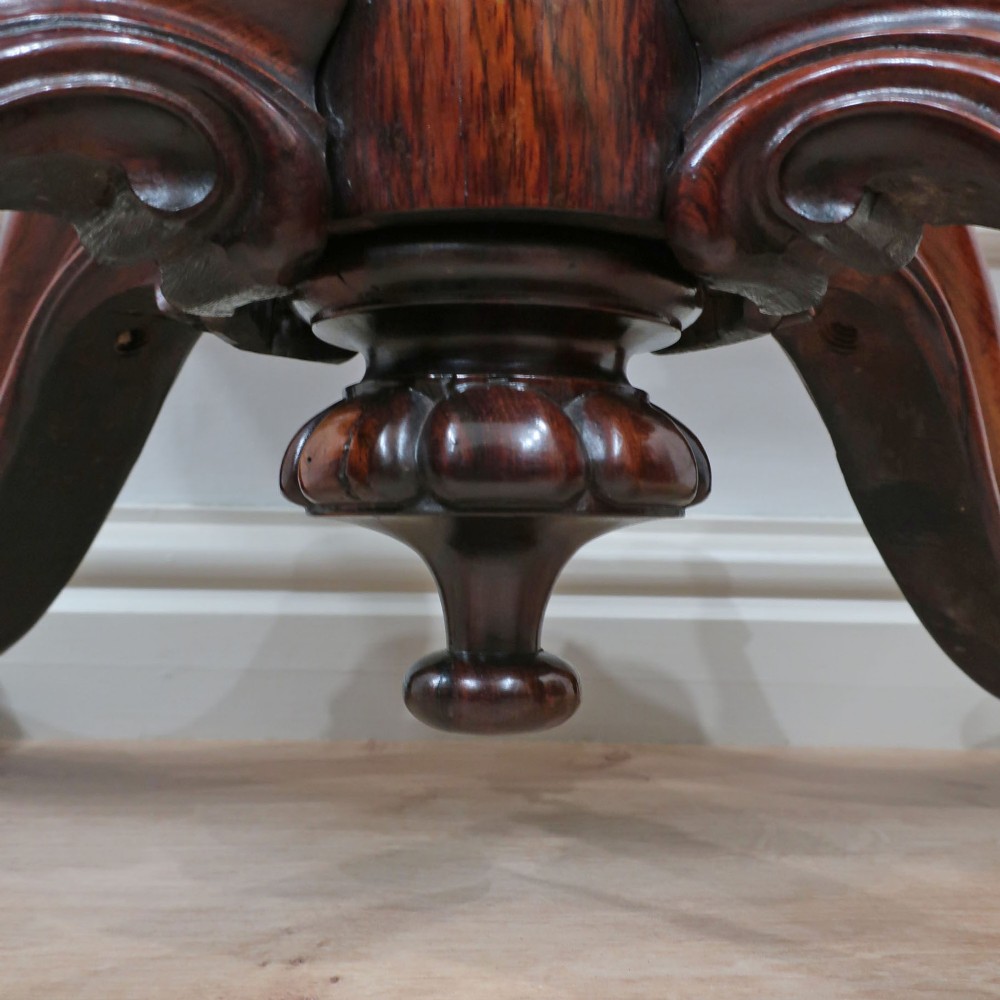 A Victorian rosewood side table featuring a serpentine fold-over top mounted on a central carved pedestal with four scroll-footed legs. View IX