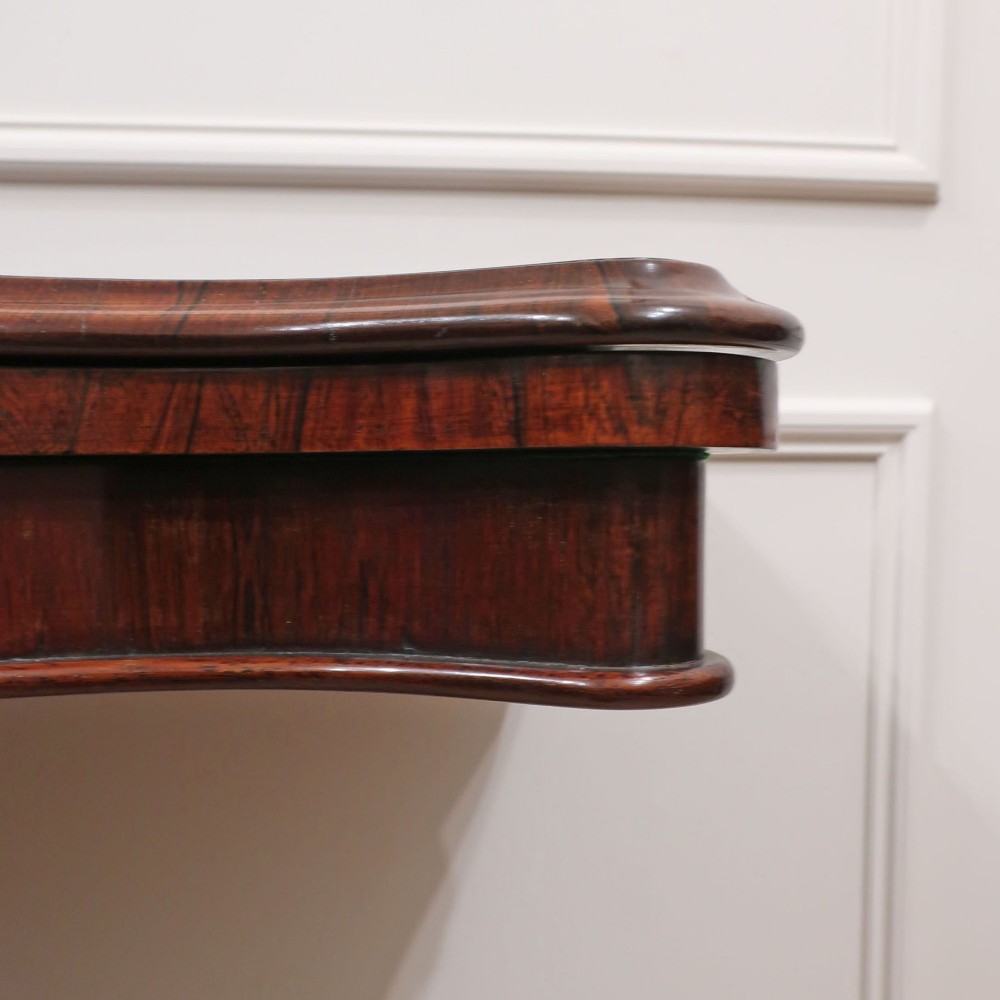A Victorian rosewood side table featuring a serpentine fold-over top mounted on a central carved pedestal with four scroll-footed legs. View XI