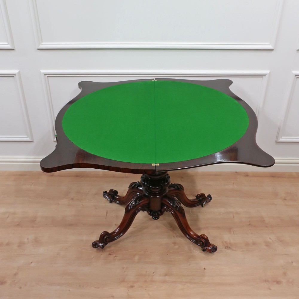 A Victorian rosewood side table featuring a serpentine fold-over top mounted on a central carved pedestal with four scroll-footed legs. View XII