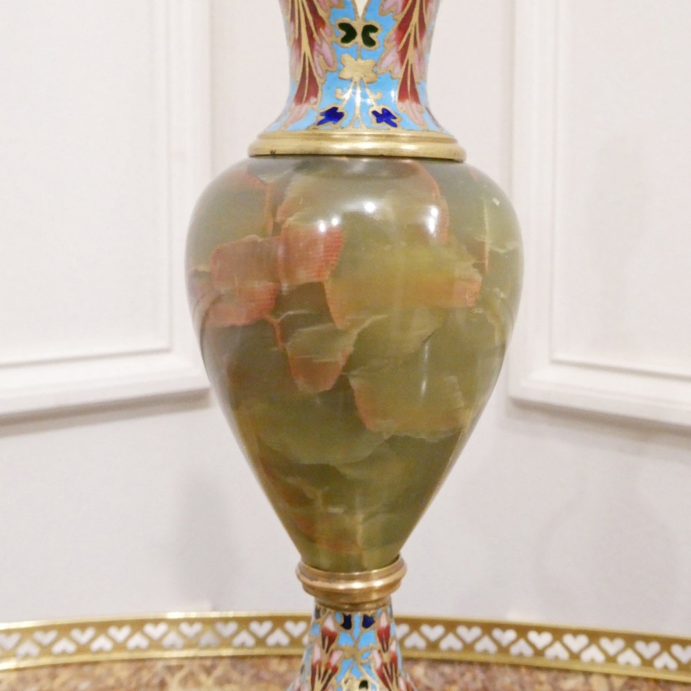 A pair of French table lamps featuring urn-shaped green onyx columns detailed with polychrome champleve enamelling and topped with pleated white shades. View V