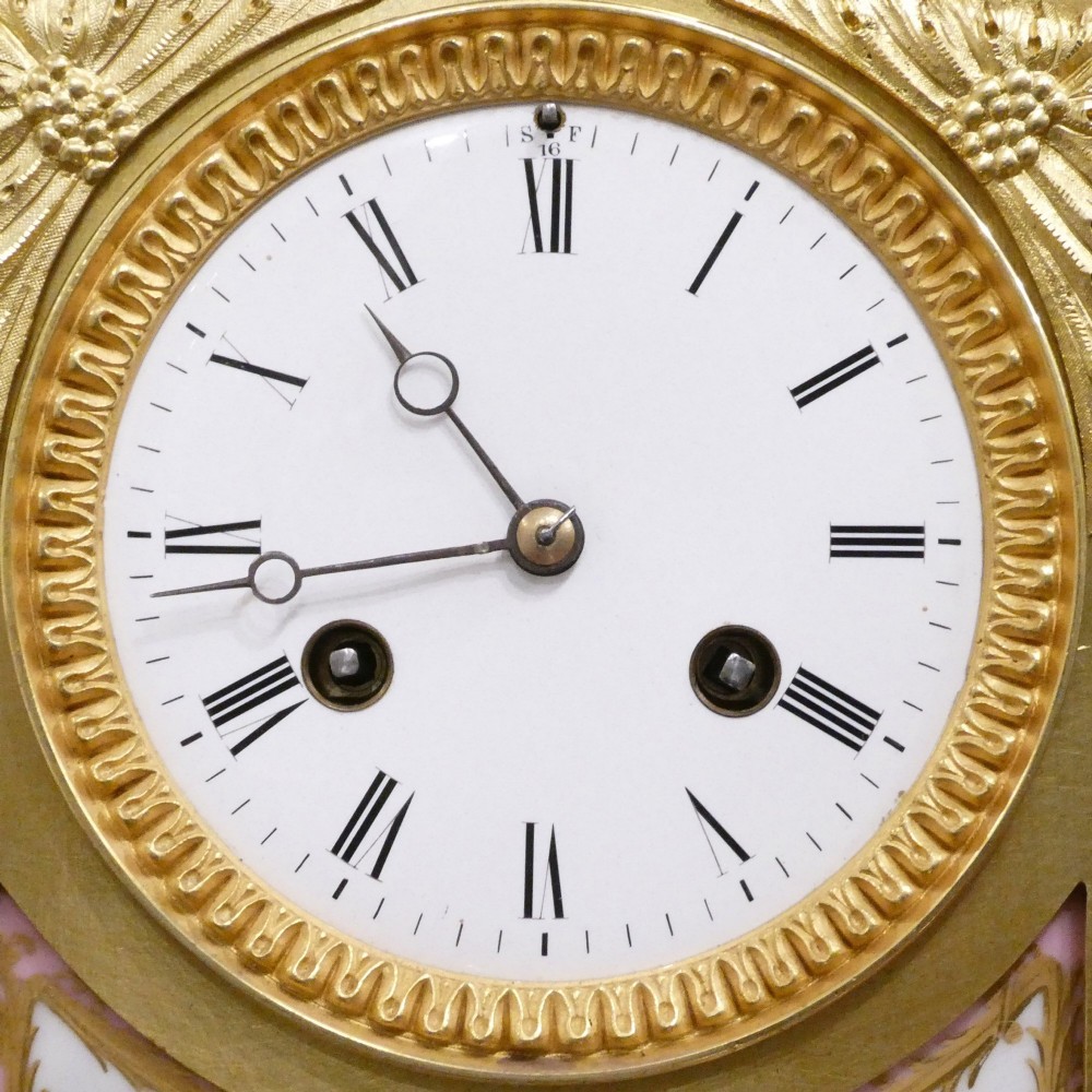 An antique French gilt bronze mantel clock featuring hand-painted pink porcelain panels, a porcelain urn finial, and an enamel dial with Roman numerals. View III