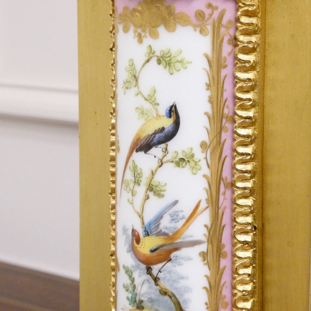 An antique French gilt bronze mantel clock featuring hand-painted pink porcelain panels, a porcelain urn finial, and an enamel dial with Roman numerals. View XI
