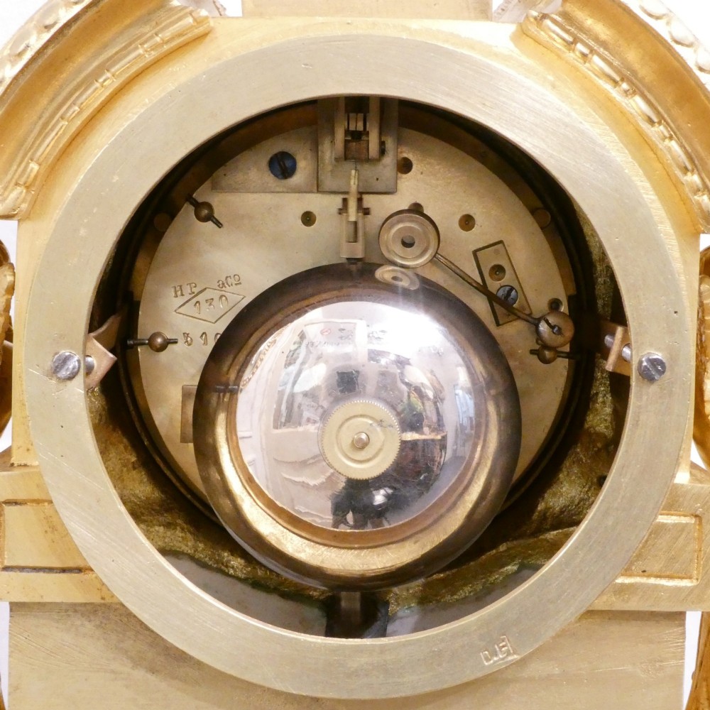A French 19th-century gilt bronze mantel clock featuring light blue hand-painted porcelain panels, sculpted putti, an urn finial, and an enamel Roman numeral dial. View XV