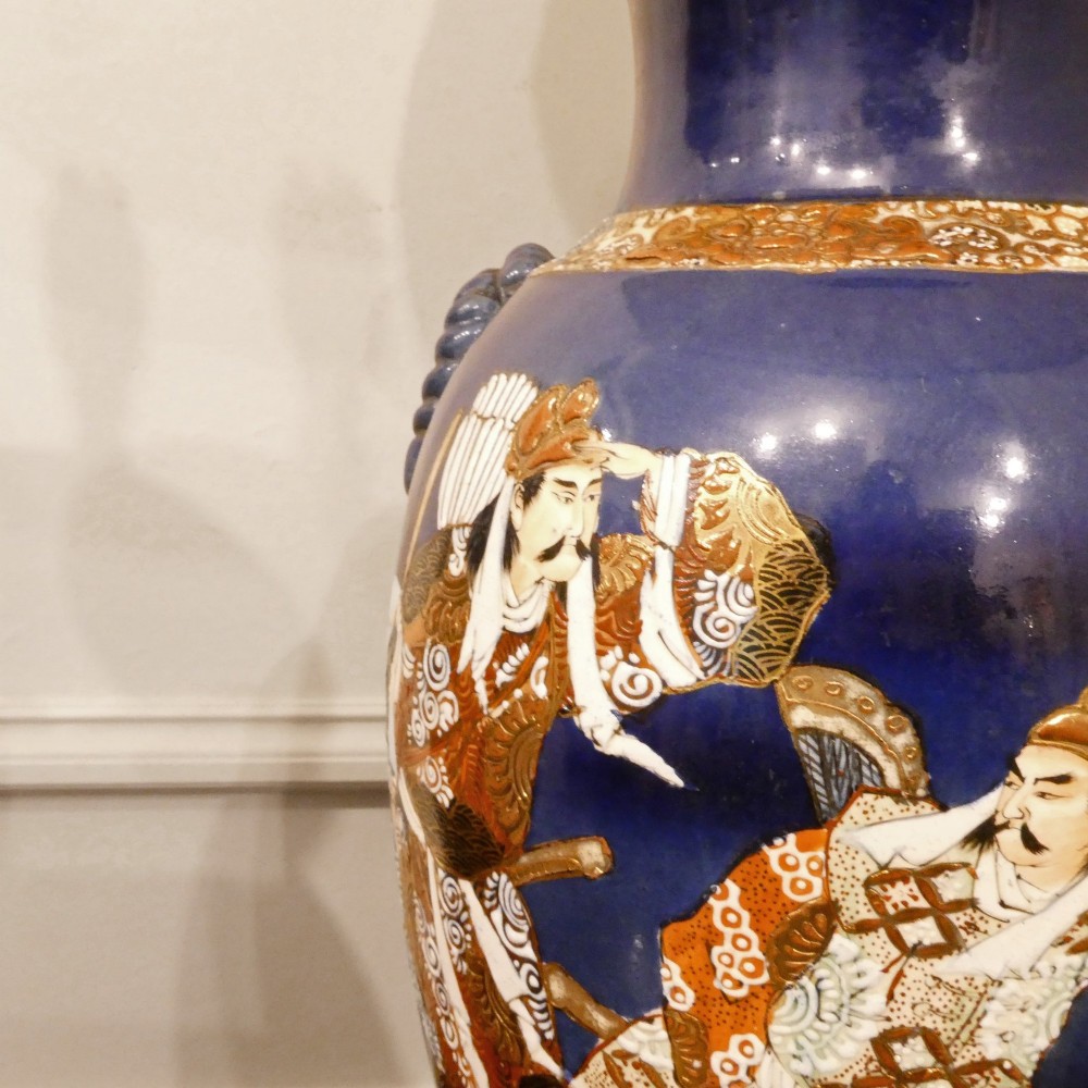 A pair of cobalt blue Japanese Satsuma porcelain table lamps decorated with gilded hand-painted figures and fitted with brass mountings and a cream pleated shade. View III