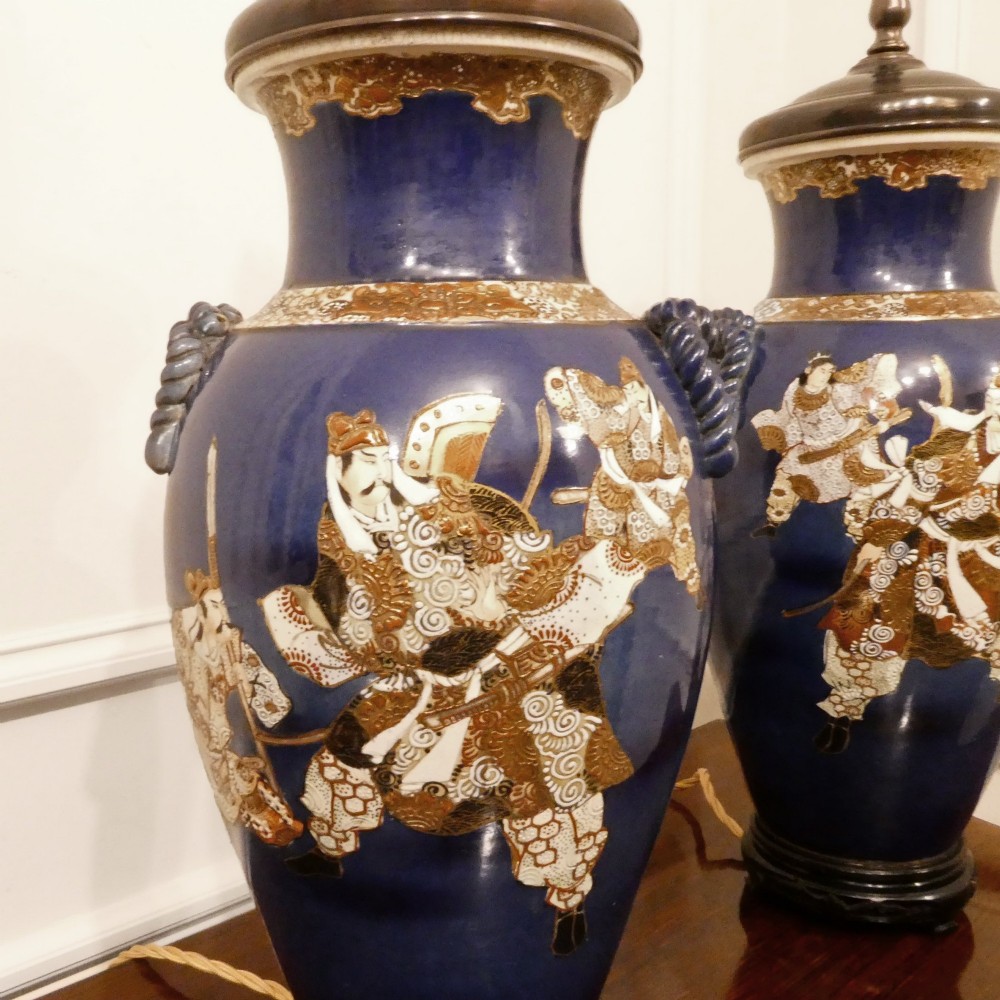 A pair of cobalt blue Japanese Satsuma porcelain table lamps decorated with gilded hand-painted figures and fitted with brass mountings and a cream pleated shade. View VIII
