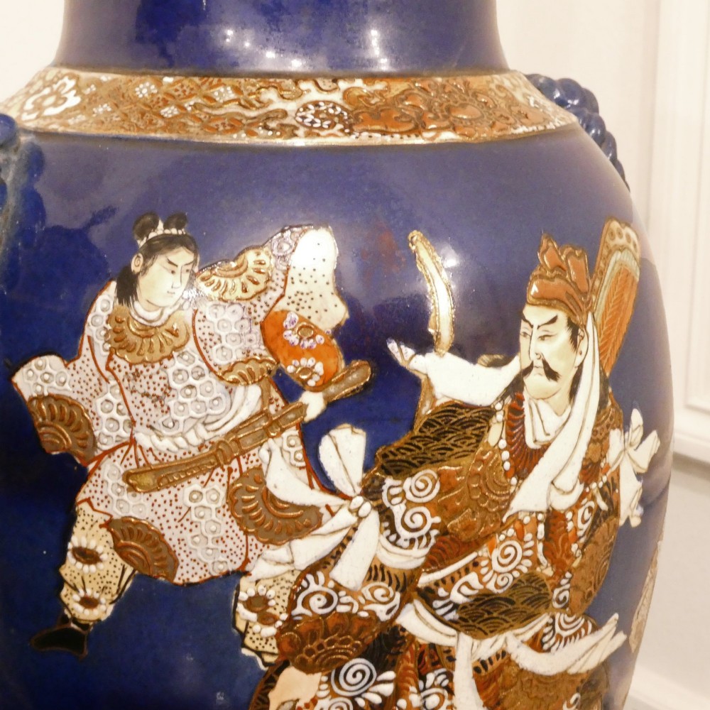 A pair of cobalt blue Japanese Satsuma porcelain table lamps decorated with gilded hand-painted figures and fitted with brass mountings and a cream pleated shade. View IX