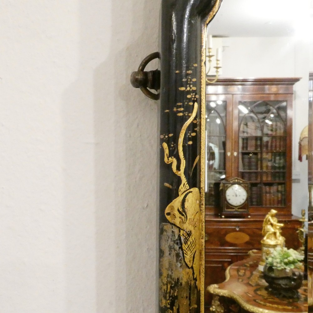 An arched wall mirror with a dark lacquered frame featuring gilded Chinoiserie motifs and segmented glass plates. View III