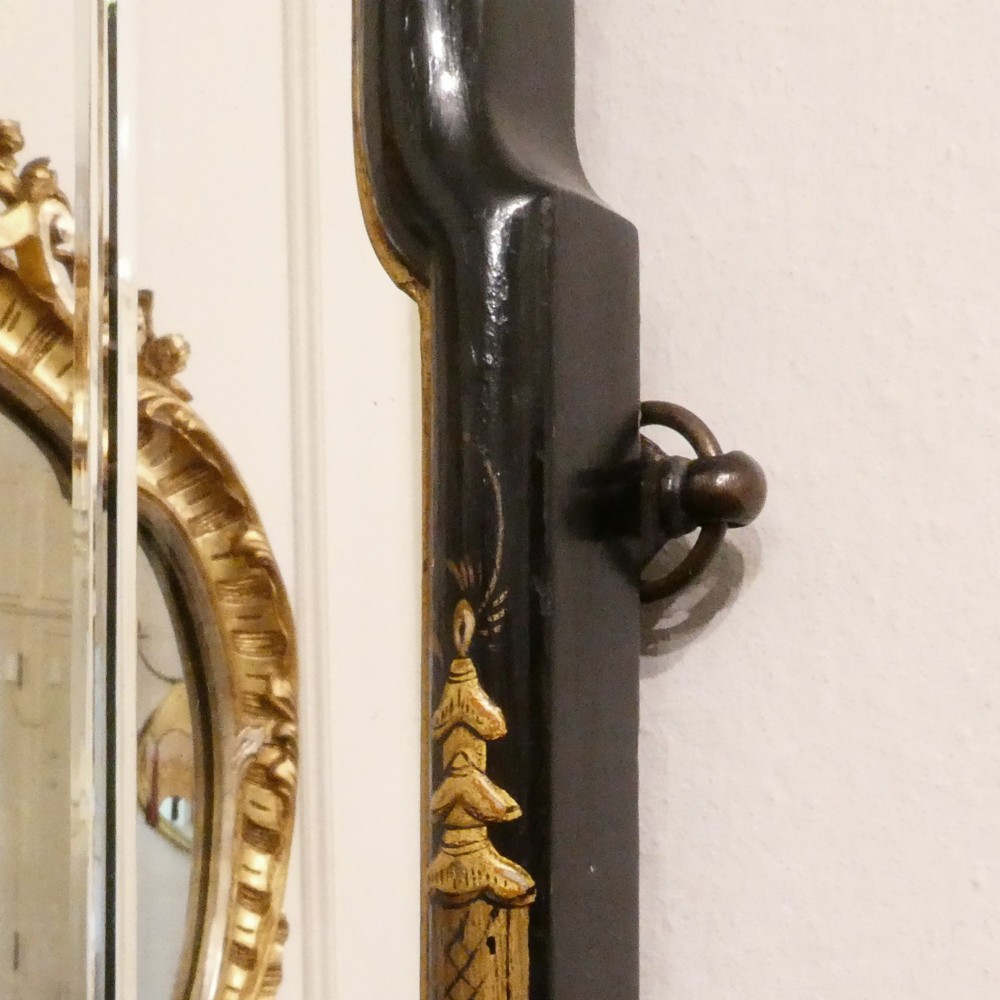 An arched wall mirror with a dark lacquered frame featuring gilded Chinoiserie motifs and segmented glass plates. View V