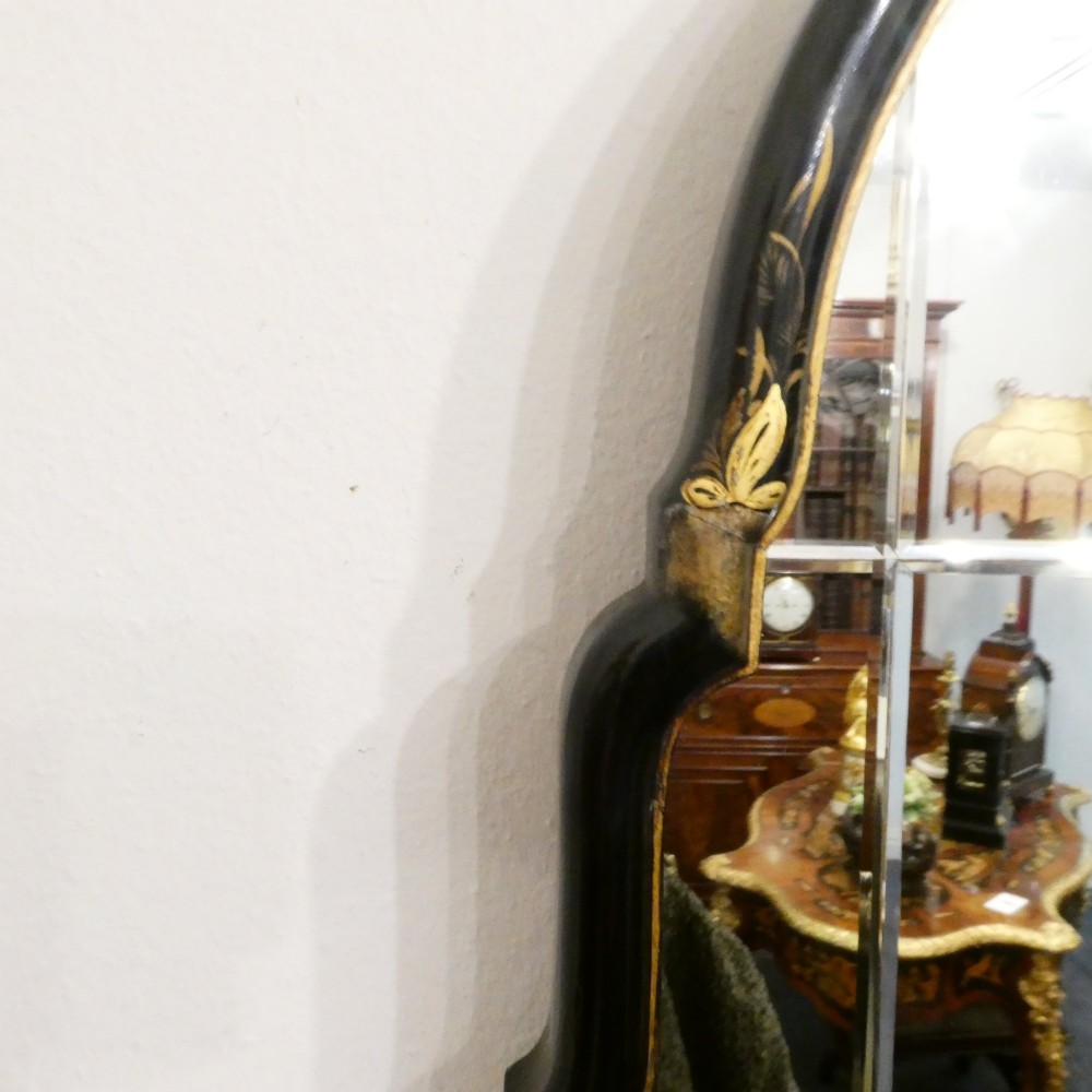 An arched wall mirror with a dark lacquered frame featuring gilded Chinoiserie motifs and segmented glass plates. View IX