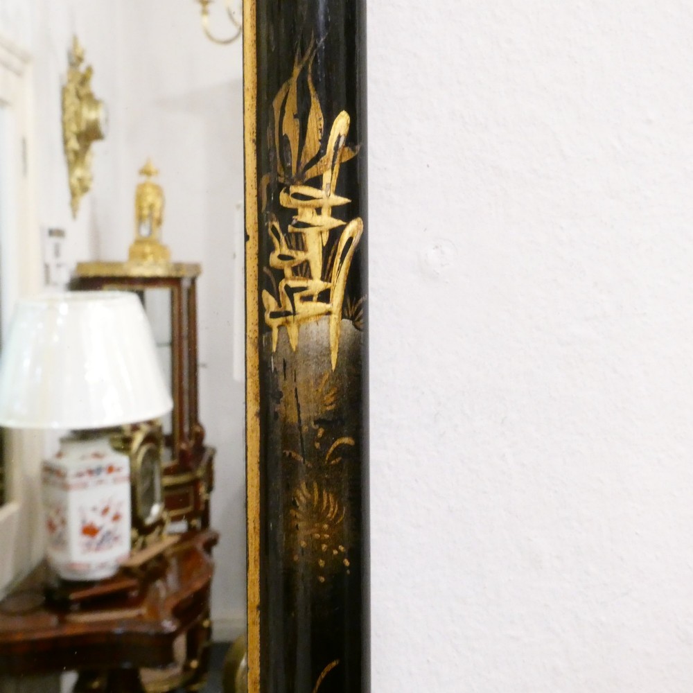 An arched wall mirror with a dark lacquered frame featuring gilded Chinoiserie motifs and segmented glass plates. View X